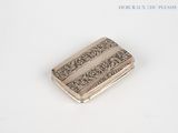 an antique silver cigarette case on a white surface