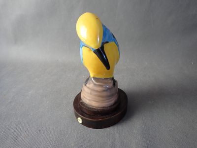 a figurine of a bird on a wooden base