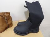 two pairs of boots and a bag on a table
