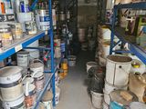 many buckets of paint on the shelves in the room
