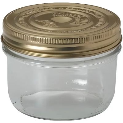 a glass jar with a gold lid on a white background