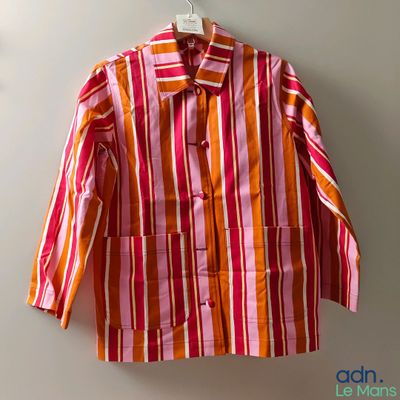 une chemise rayée suspendue à un cintre accroché au mur d'une pièce