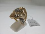 gros plan d'une bague en or avec des diamants sur une surface blanche
