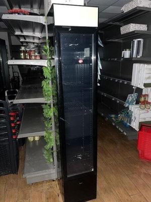 a refrigerator in the middle of a store with shelves full of food