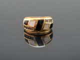 a close up of a gold ring with black and white stones