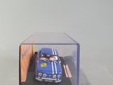 a small blue car in a clear box on a white surface