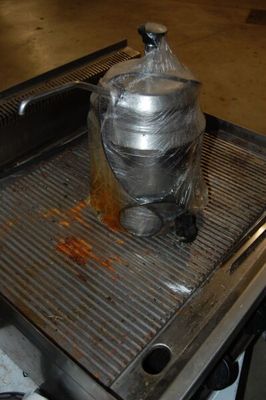 un récipient en métal posé sur une grille métallique