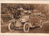 une vieille photo d'une voiture d'époque garée sur le bord de la route