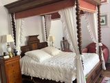 a bed with a canopy in a room with a pink rug
