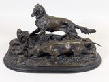 statue en bronze représentant un chien et deux chiens dans un champ