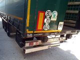 a green truck with a yellow stripe on the back of it