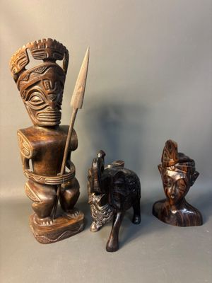 three wooden statues of a man and a woman and a dog