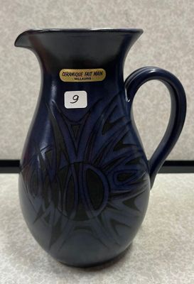 un vase bleu posé sur une table, avec une étiquette de prix dessus