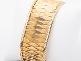 an image of a close up of a gold bracelet on a napkin