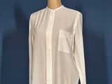 a white shirt on a mannequin stand against a blue wall