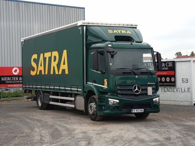un camion vert garé devant un immeuble