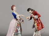 une paire de figurines représentant un homme et une femme se tenant la main