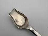 silver spoon on a white surface with a small spoon sticking out of it