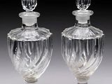 une paire de flacons de parfum en verre transparent posés sur une table