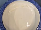 a blue and white plate with a blue rim on a table