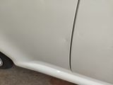 a close up of a white car with a broken door handle