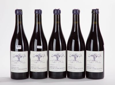 six bottles of wine are lined up in a row on a white surface
