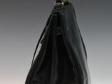 the large black bag is sitting on a white surface