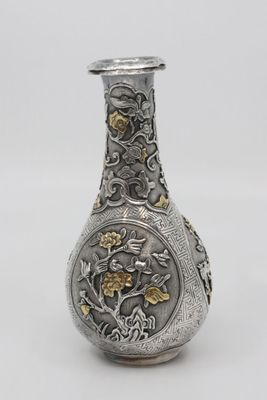l'image d'un vase en argent orné d'une décoration en or