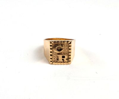 gros plan d'une bague en or sur une surface blanche