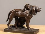 statue en bronze représentant un chien et un chat assis sur une table