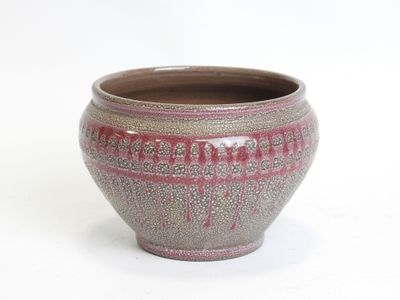 a brown and pink vase sitting on a white surface