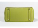a green purse with a zipper on the front and a zipper on the back