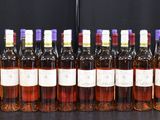 Des bouteilles de vin sont alignées sur une table devant un fond noir.