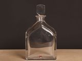 une bouteille en verre transparent posée sur une table en bois