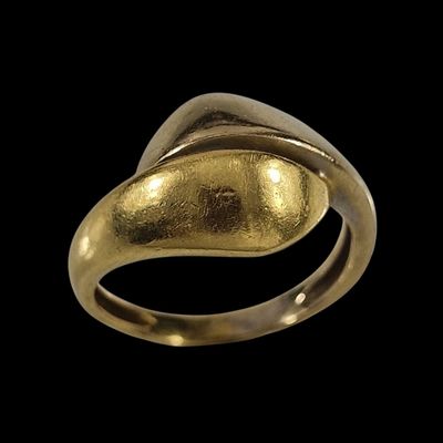 gros plan d'une bague en or sur fond noir