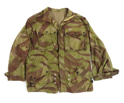 La veste est de couleur camouflage et comporte des boutons sur la poitrine.