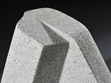 a close up view of a concrete object with a black background