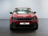 the front end of a red jeep parked in a white room