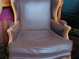 un fauteuil en cuir marron placé devant une bibliothèque