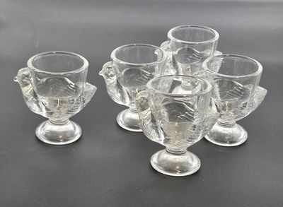six clear glass goblets sitting on top of a black table