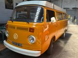 an orange vw bus parked in a garage