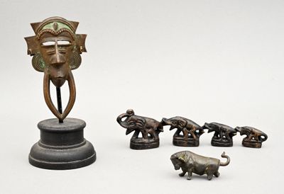 une statue représentant un homme dont la tête repose sur un socle, entourée d'autres figurines