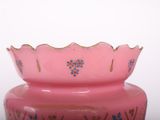 a pink vase sitting on a table next to a white wall