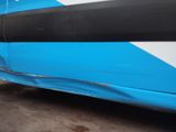 a close up of a blue and white bus parked in a parking lot