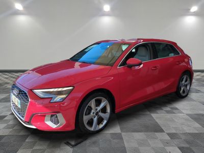 Une Audi rouge est garée sur un sol carrelé à damier.