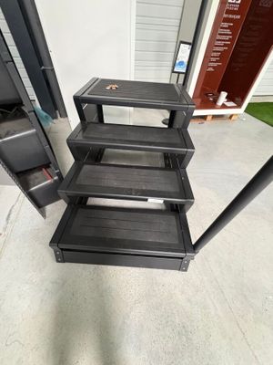 une photo d'une étagère en métal noir comportant quatre tablettes