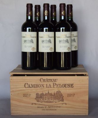 four bottles of wine are in a wooden box on a table