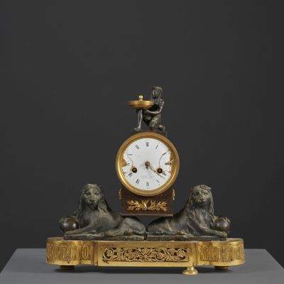 a gold clock with a statue of a man on top of it