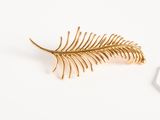 une broche en feuille d'or sur un fond blanc