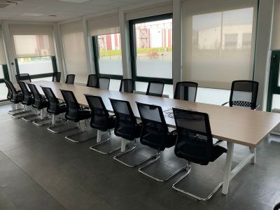 des tables et des chaises dans une grande salle de conférence dotée de grandes fenêtres
